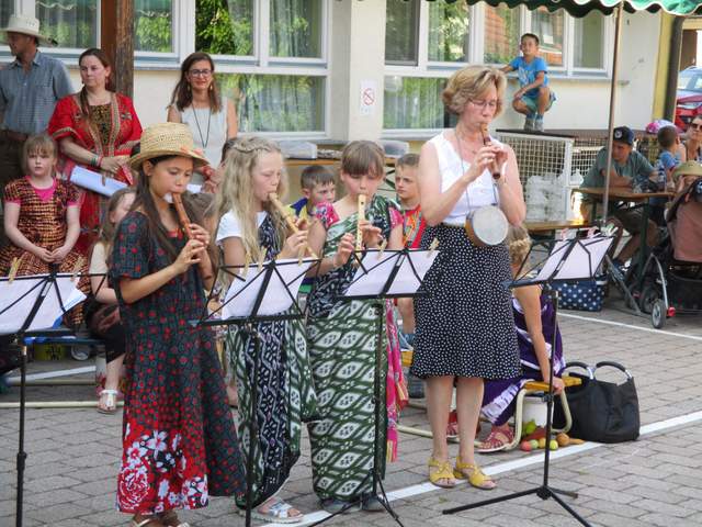 Sechs Schülerinnen spielen konzentriert Flöte bei einem Auftritt